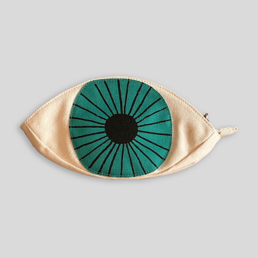 Eye-shaped pouch with green and black design on a gray background